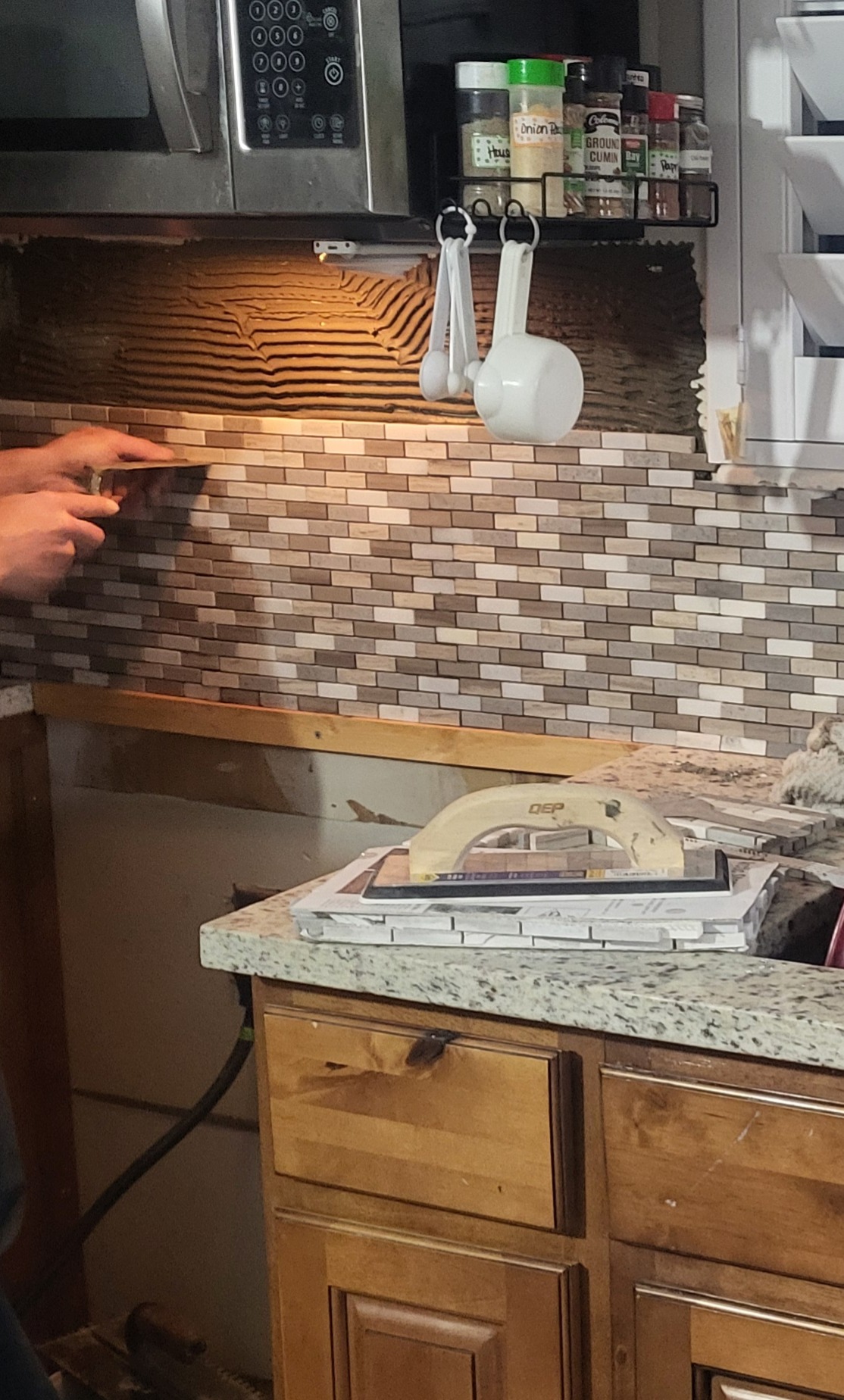 finishing putting the backsplash behind the stove